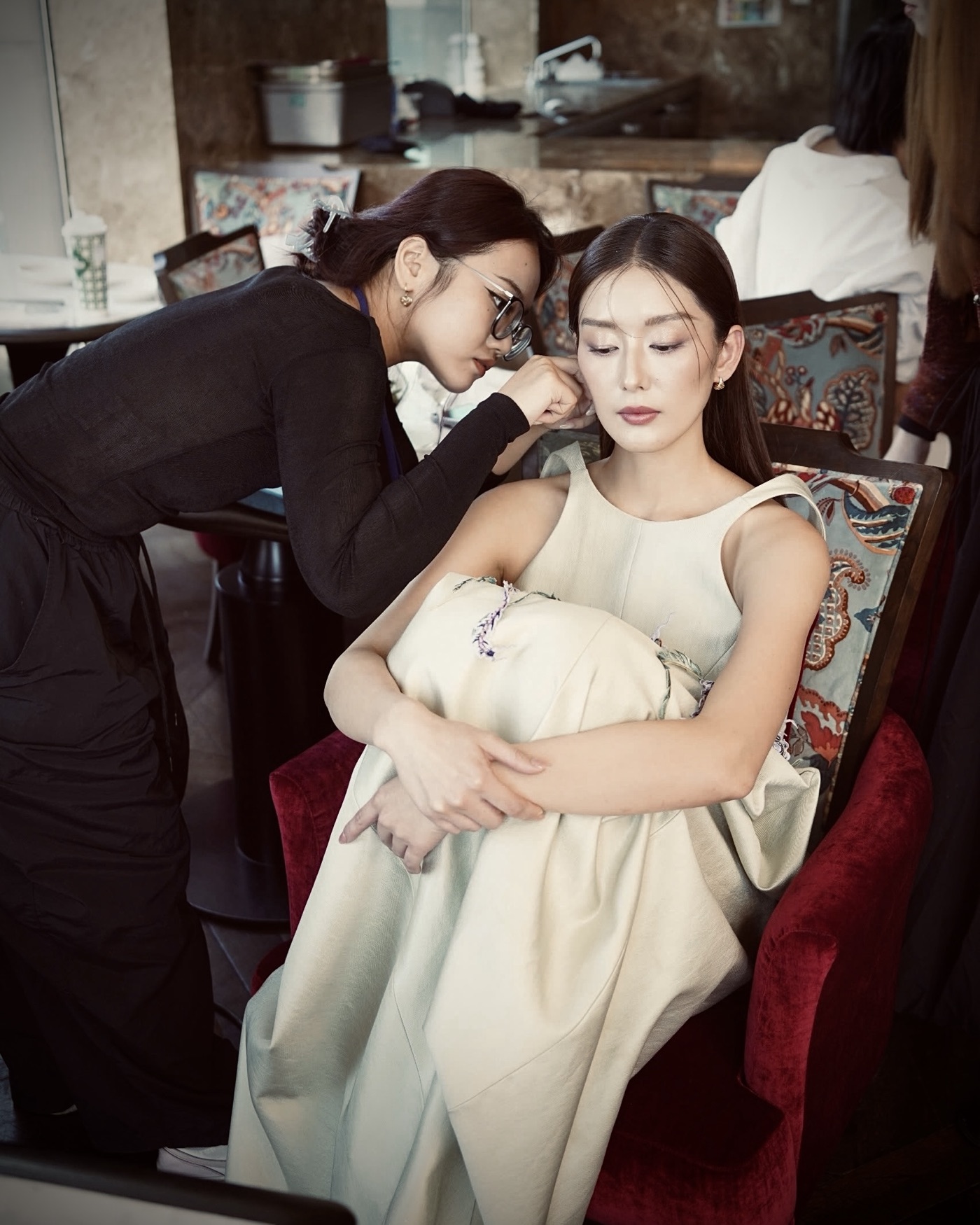 Fastening a CAO earring on talent before a shoot